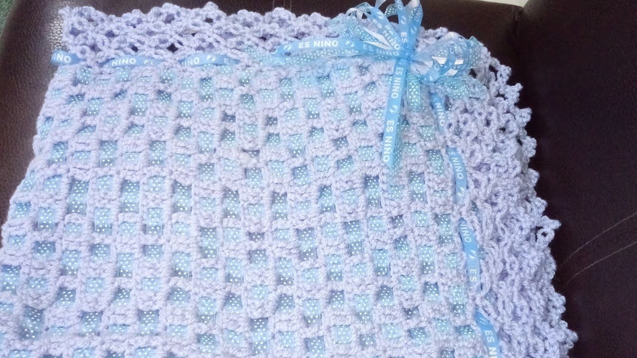 Hermosa cobija tejida a crochet decorada con listón