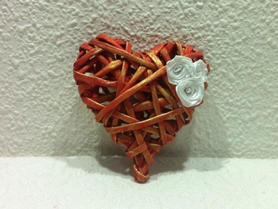 Corazón con regalo escondido, hecho con tubitos de papel periódico