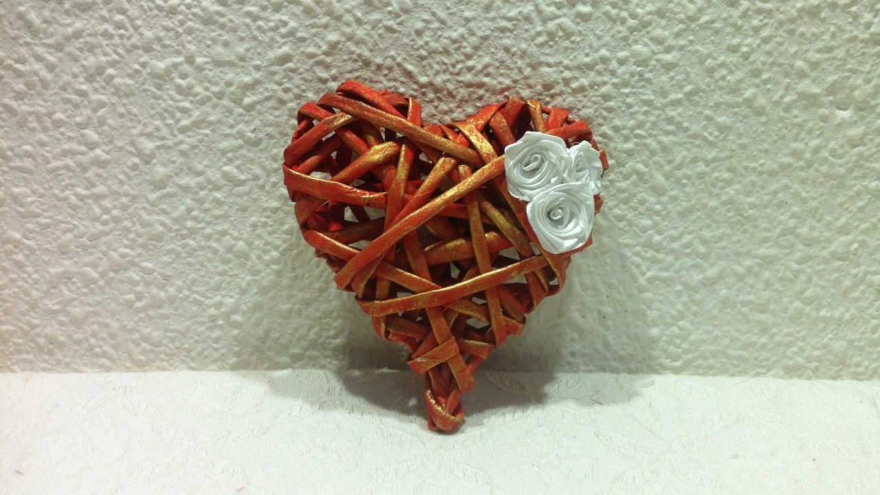 Corazón con regalo escondido, hecho con tubitos de papel periódico