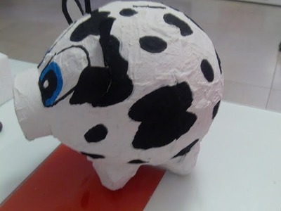 Alcancia de vaca con un globo y carton de huevo