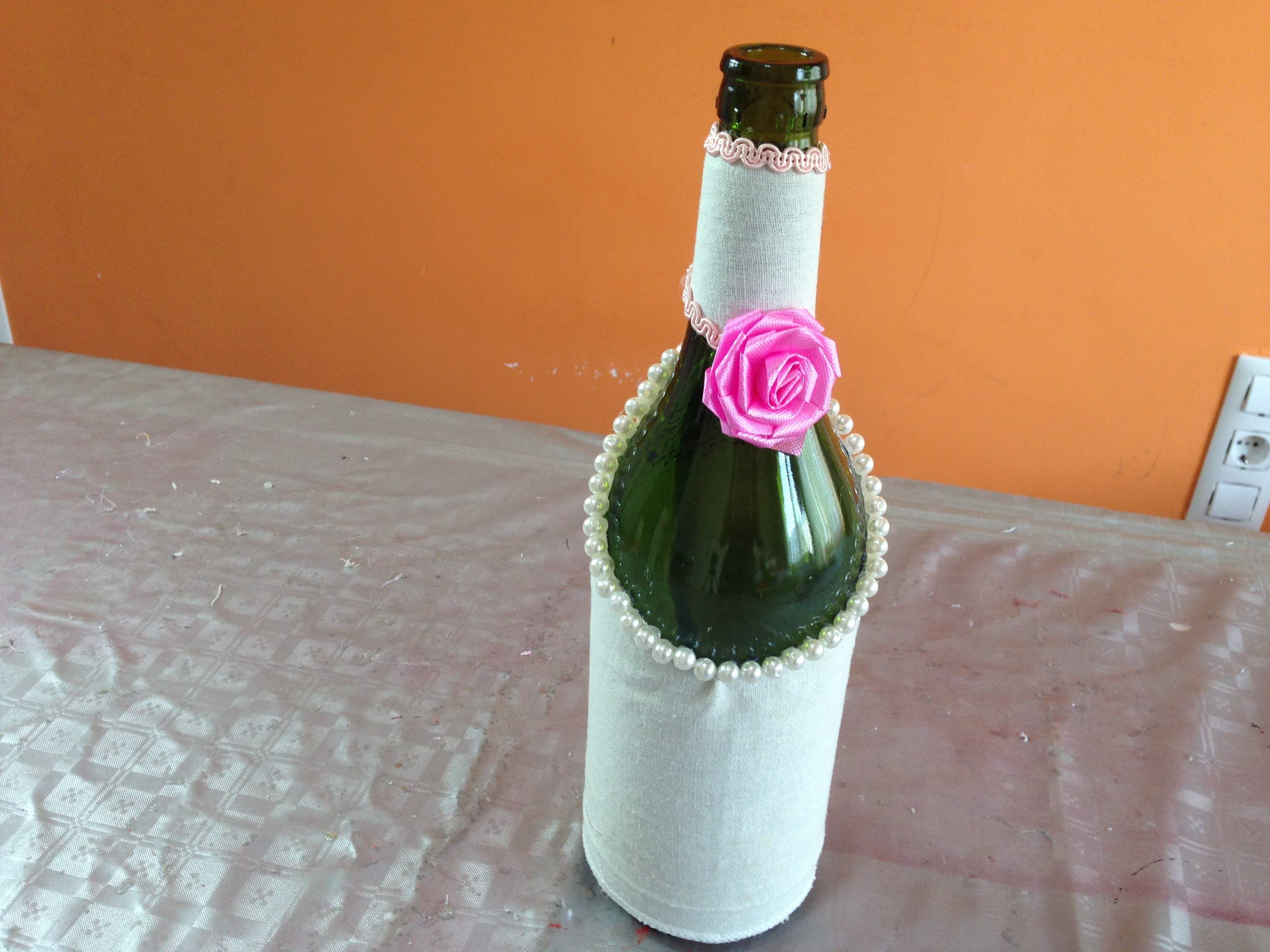 Botella decorada con tela y perlas