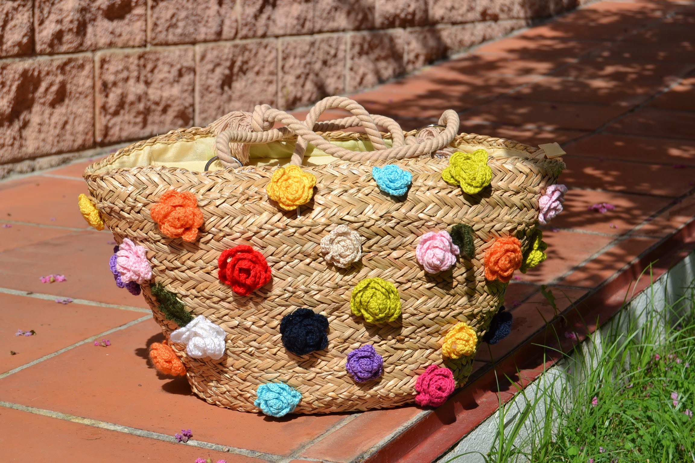 Bolso de paja  adornado con flores de crochet.